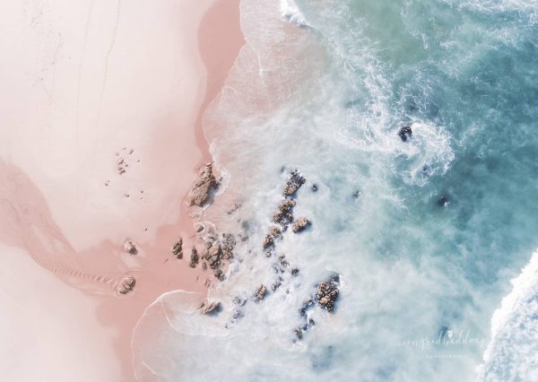 Sea Bliss - Aerial beach photograph. Sea Bliss with dreamy pastel coloured ocean waters and soft ripples of the waves hitting the pink toned shore